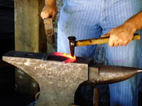 blacksmith forging horseshoe on anvil