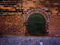 Victorian brick wall with coal bin door