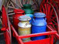 old milk cans sitting on a wagon